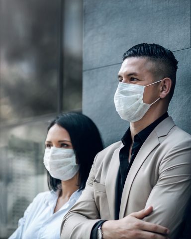 Two people wearing medical face masks